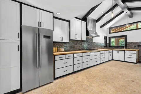 a kitchen with granite countertop a refrigerator and a sink