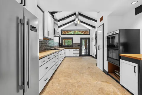 a large kitchen with window and stainless steel appliances
