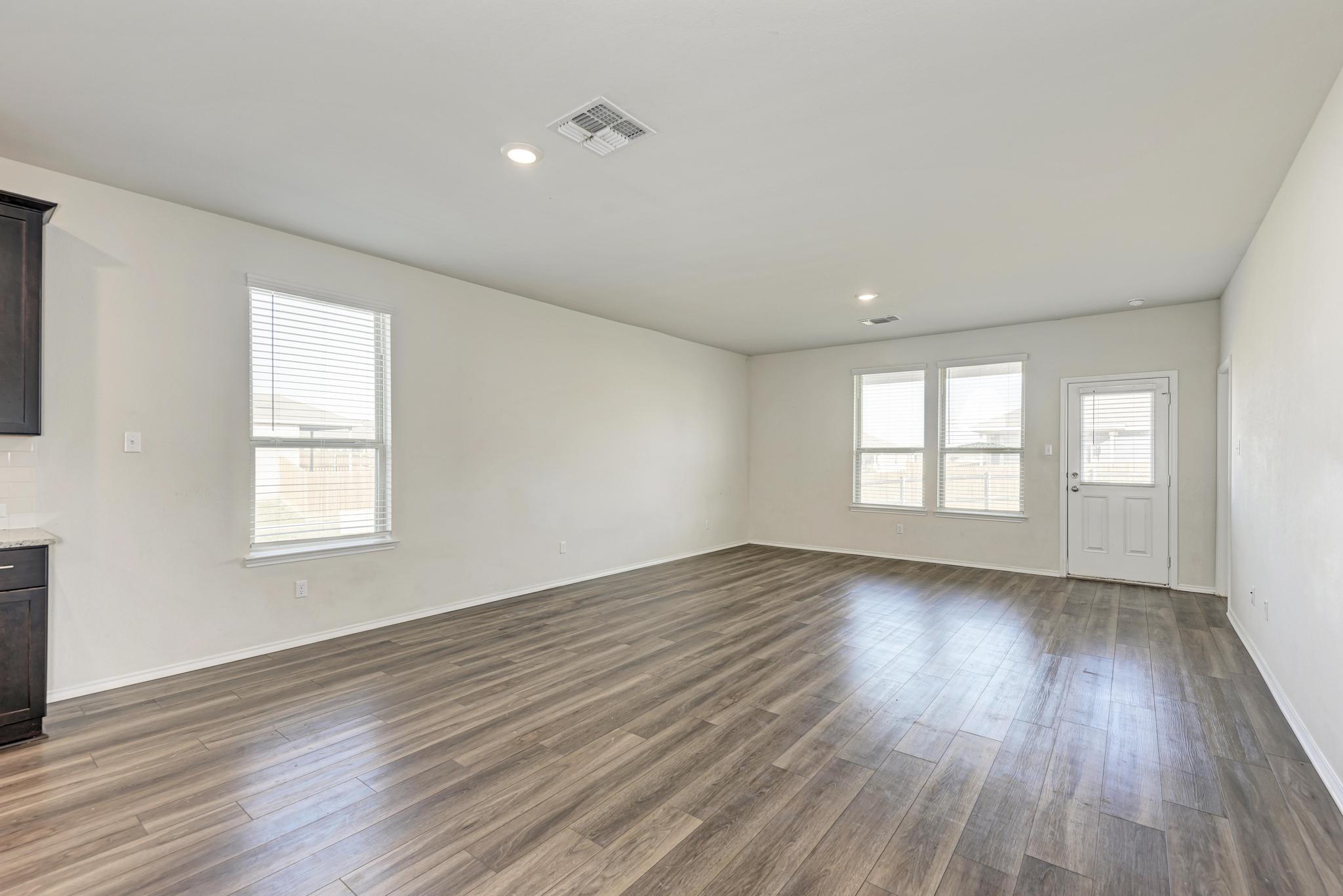 201 Pivot Drive Taylor, TX 76574 - Photo 11 of 34 a view of an empty room with wooden floor and window