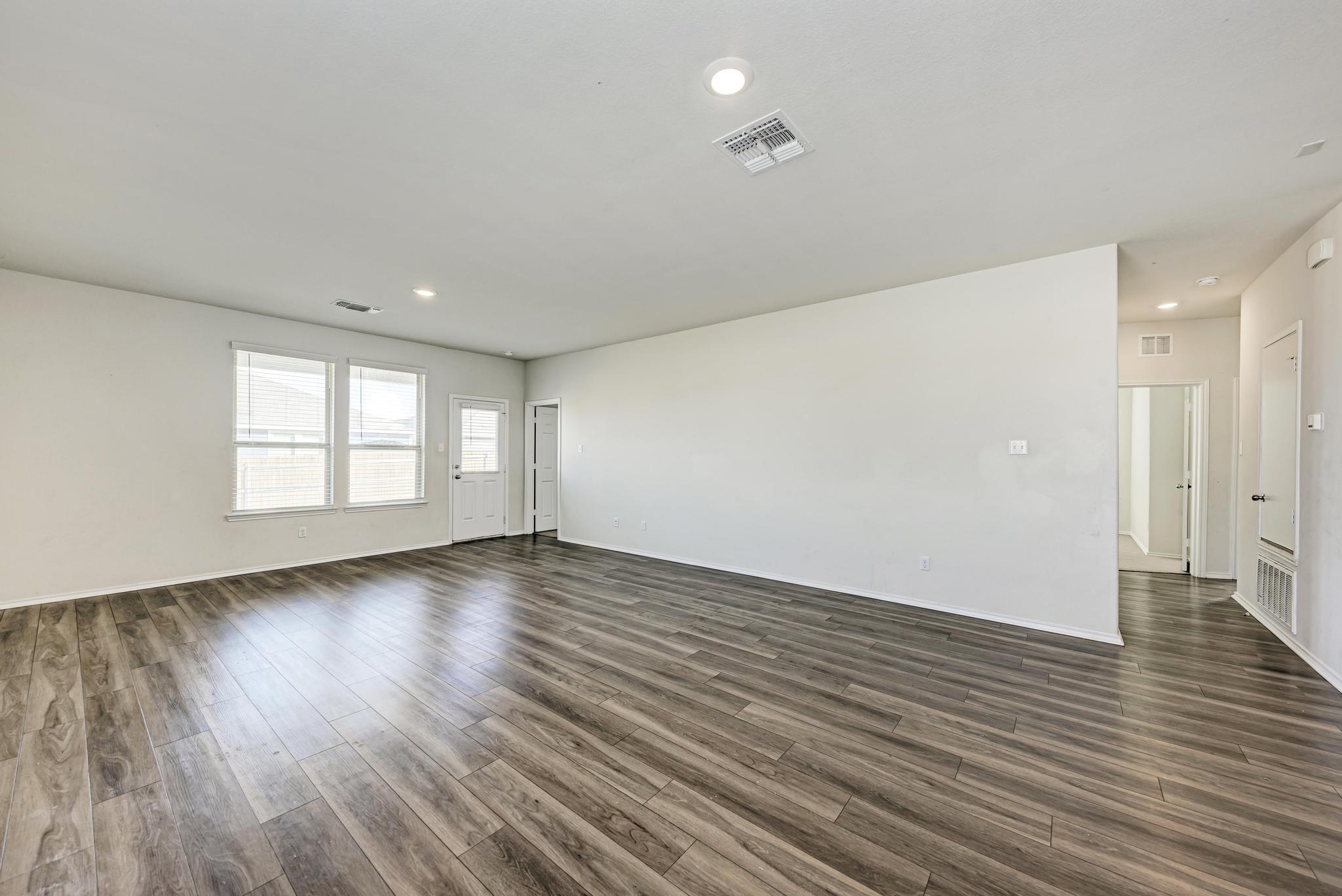 201 Pivot Drive Taylor, TX 76574 - Photo 12 of 34 an empty room with wooden floor and windows