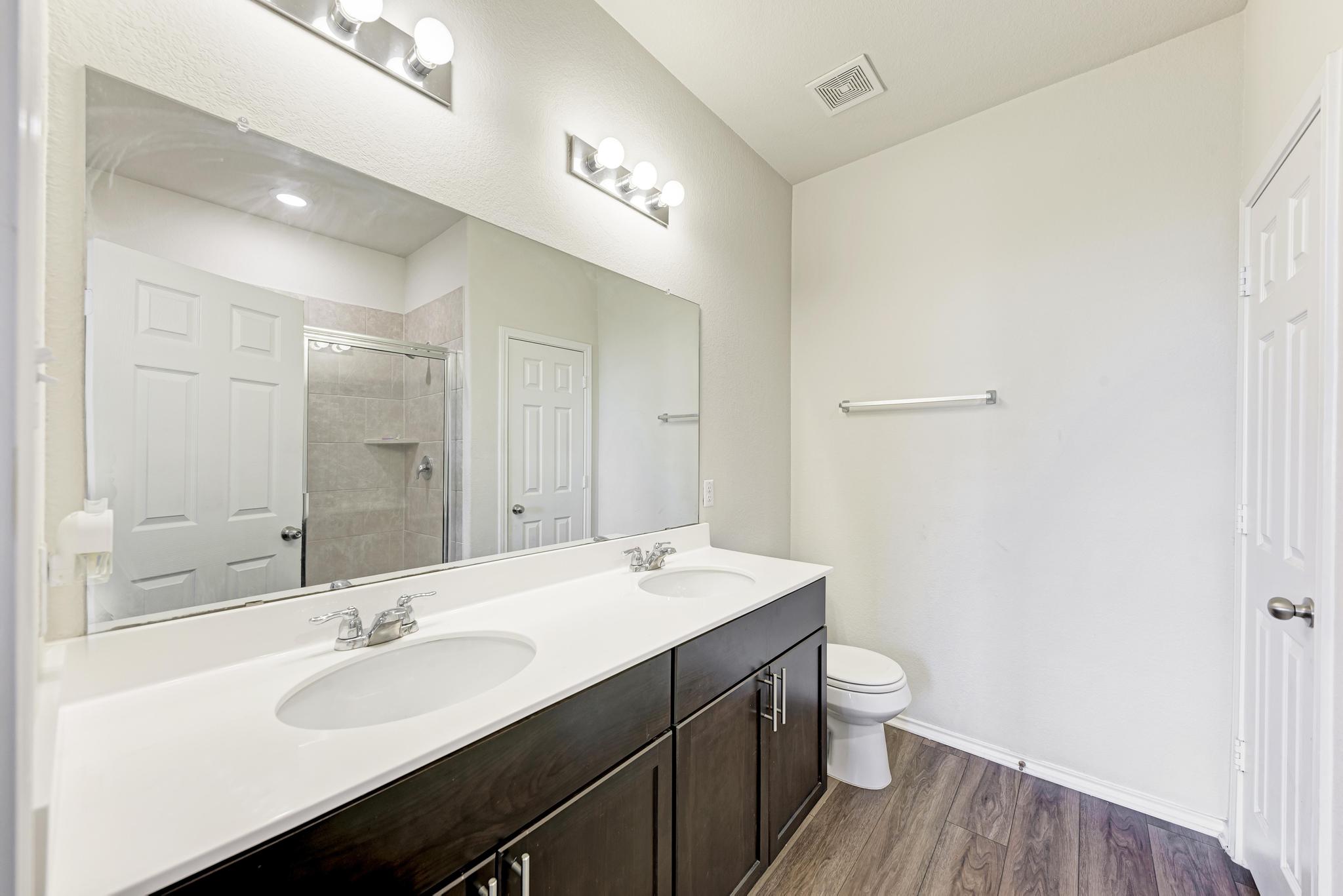 201 Pivot Drive Taylor, TX 76574 - Photo 17 of 34 a bathroom with a double vanity sink and a mirror