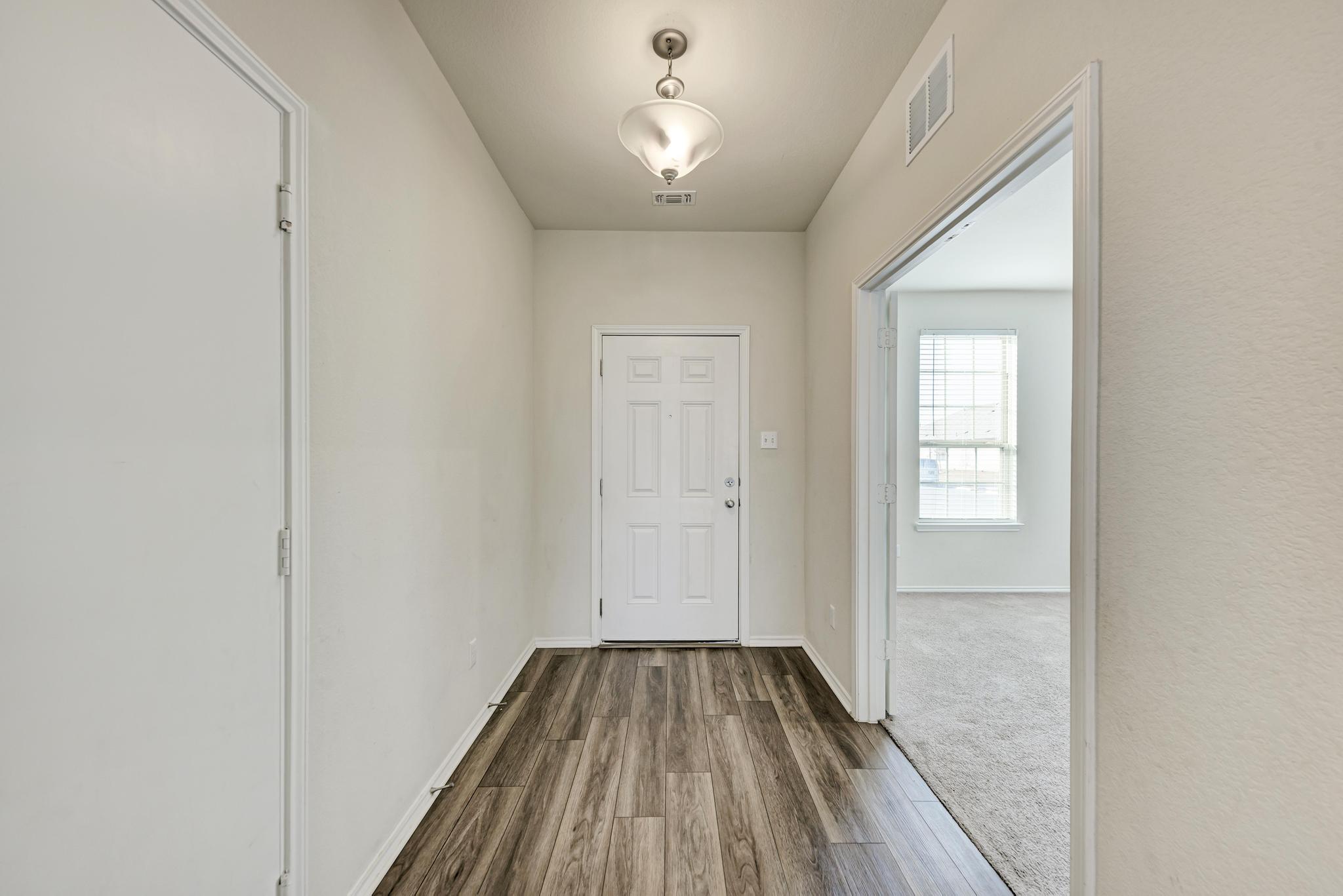 201 Pivot Drive Taylor, TX 76574 - Photo 4 of 34 a view of a hallway with wooden floor and a bathroom