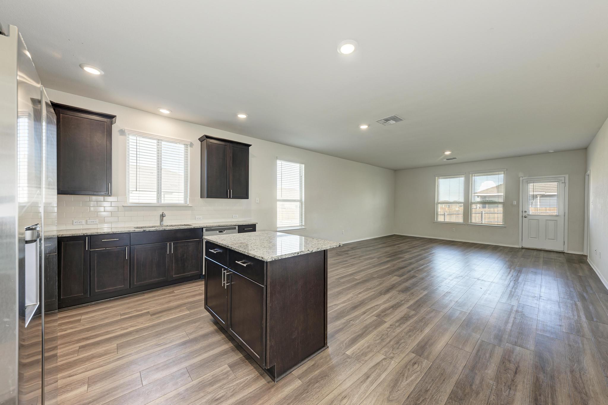 201 Pivot Drive Taylor, TX 76574 - Photo 5 of 34 a kitchen with stainless steel appliances granite countertop a stove a sink and a microwave