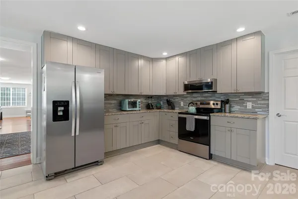 a kitchen with stainless steel appliances granite countertop a refrigerator and a stove top oven