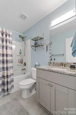 a bathroom with a granite countertop sink toilet and shower