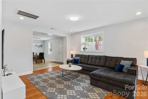 a living room with furniture and wooden floor