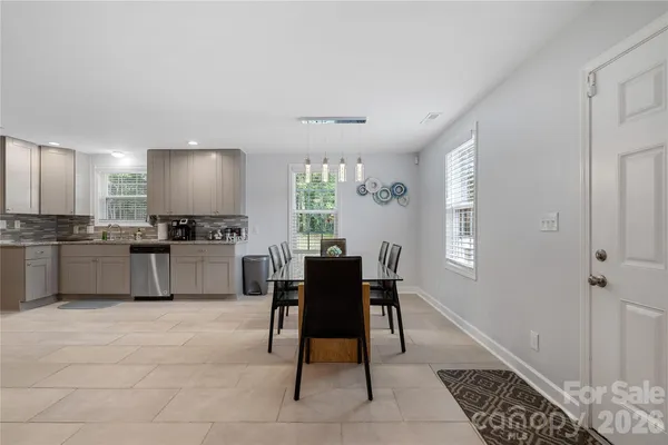 a kitchen with a dining table chairs and refrigerator