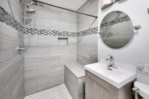 a bathroom with a sink a shower and a mirror
