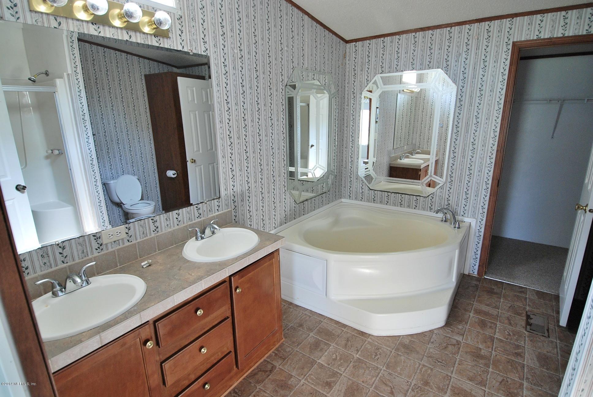 54525 Marlee Road Callahan, FL 32011 - Photo 9 of 22 a bathroom with a tub sink and mirror
