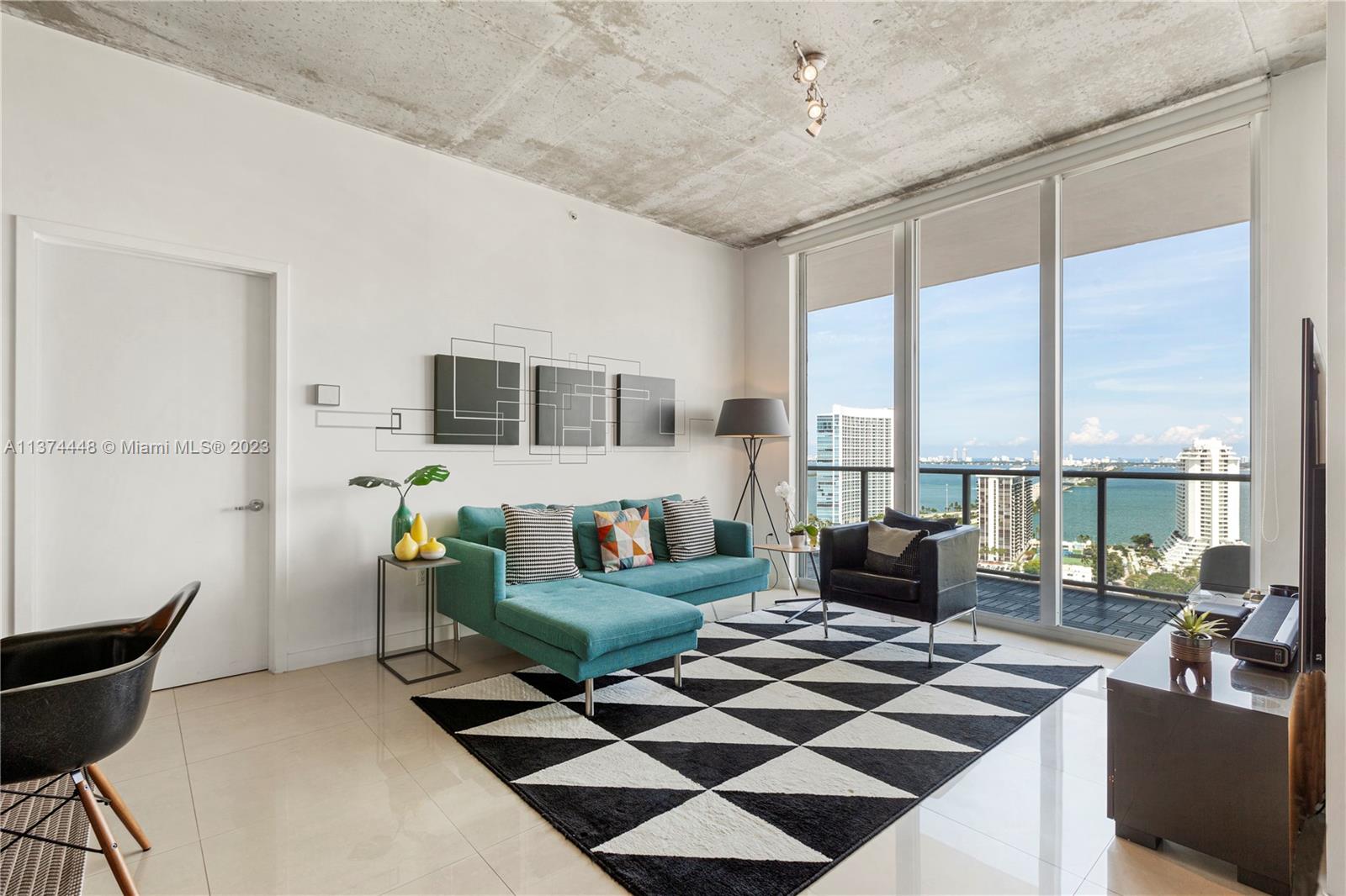 3470 East Coast Avenue, Unit H2410 Miami, FL 33137 - Photo 1 of 46 a living room with furniture and a floor to ceiling window