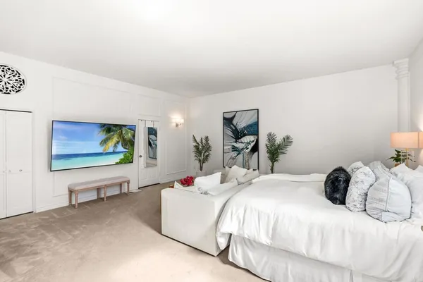 a bedroom with a bed and a flat screen tv