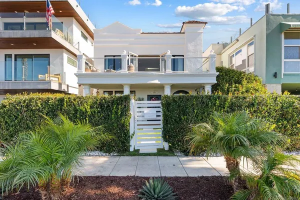a front view of a house with a yard and potted plants