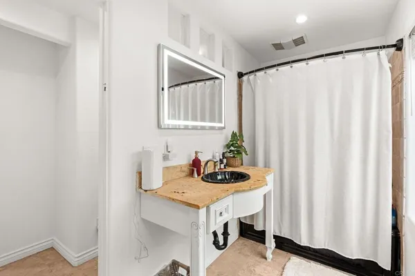 a bathroom with a sink a mirror and a shower curtain