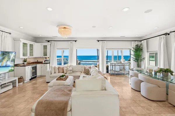 a living room with furniture and a kitchen area with a fireplace