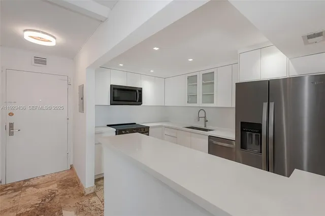 a kitchen with stainless steel appliances a refrigerator stove microwave and sink