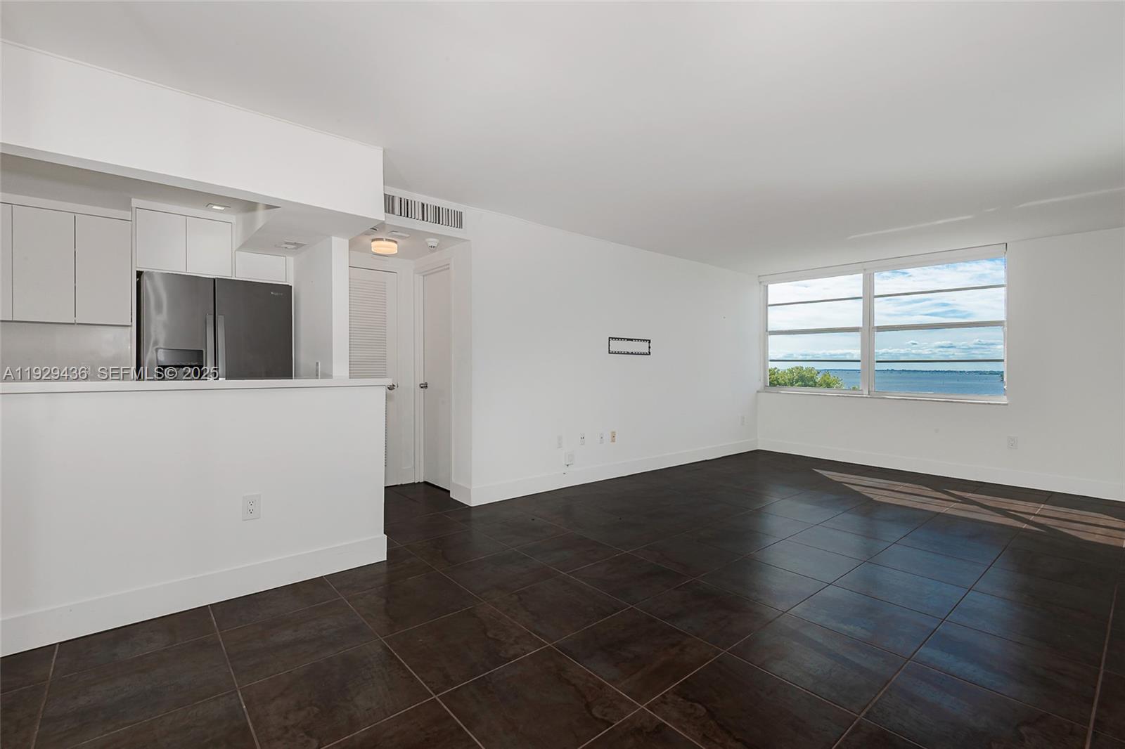 150 Southeast 25th Road, Unit 7J Miami, FL 33129 - Photo 4 of 29 an empty room with wooden floor and windows