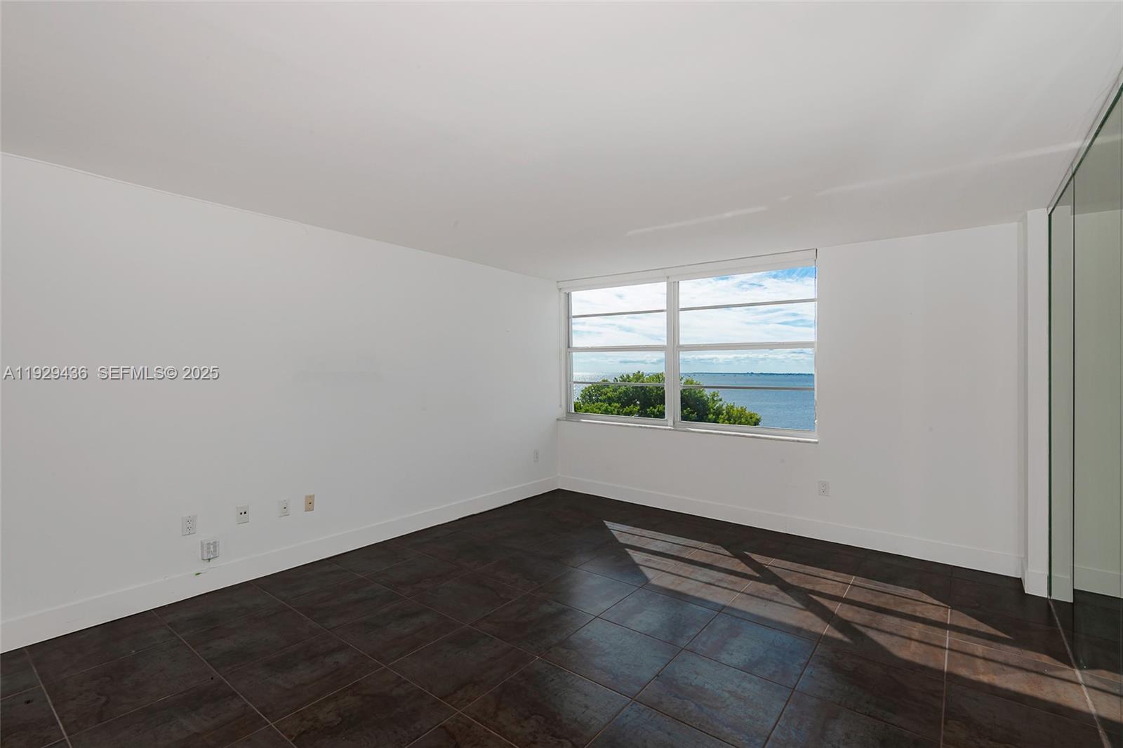 150 Southeast 25th Road, Unit 7J Miami, FL 33129 - Photo 5 of 29 an empty room with wooden floor and windows