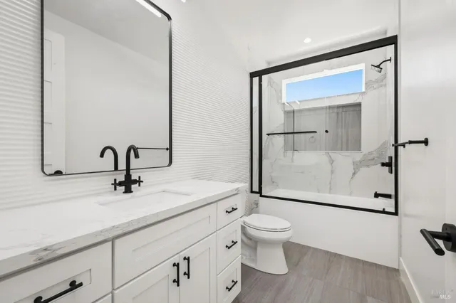 a bathroom with a sink a toilet a mirror and shower