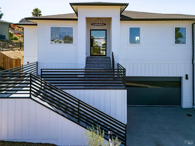 a kitchen with white cabinets and chairs