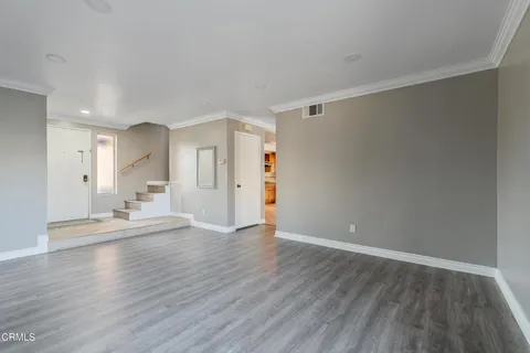 a view of empty room with wooden floor