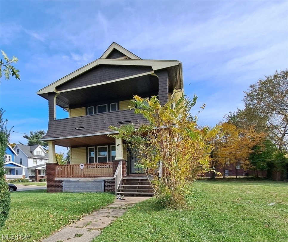 View of front of house featuring a front lawn and a balcony