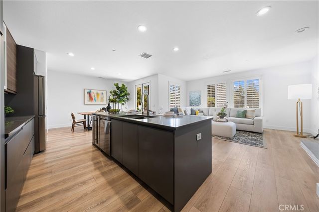 a kitchen with stainless steel appliances granite countertop a sink counter space and wooden floor