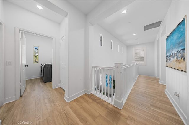 a view of a hallway with wooden floor and closet