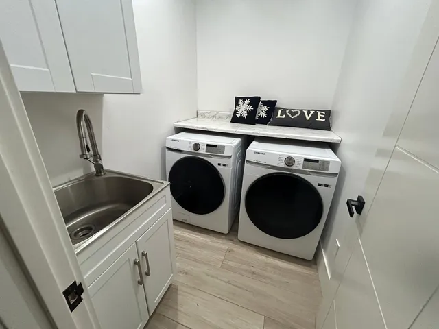 a utility room with sink dryer and washer