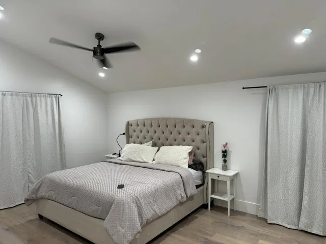 a bedroom with a bed and a ceiling fan