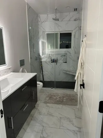a bathroom with a sink a toilet and shower