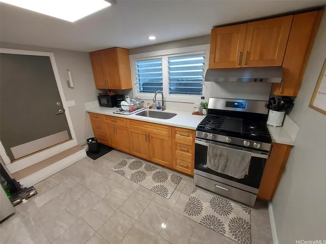 a kitchen with stainless steel appliances a stove a sink and a refrigerator