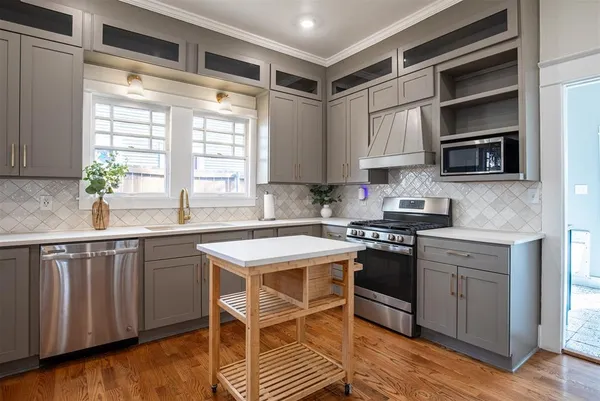 a kitchen with stainless steel appliances granite countertop a stove a sink and a microwave