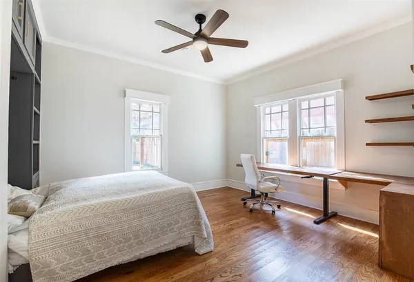 a bedroom with a bed a large window and a chandelier