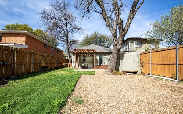 a view of a house with backyard and a tree