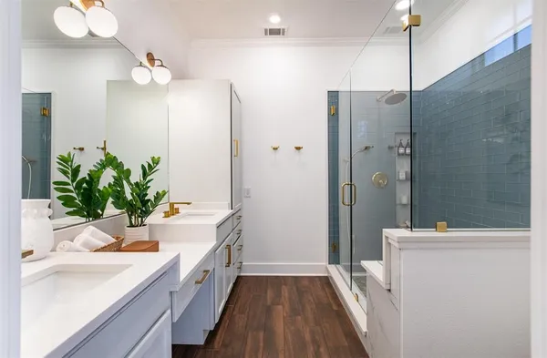 a bathroom with a double vanity sink a large mirror a shower and a bathtub