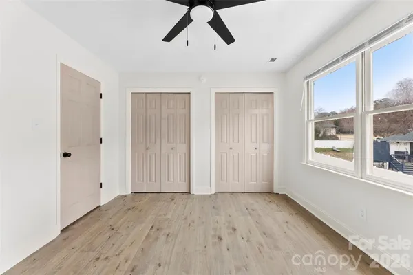 a view of empty room with wooden floor and window