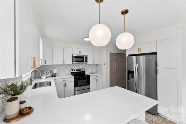 a kitchen with stainless steel appliances kitchen island granite countertop a sink a stove and refrigerator