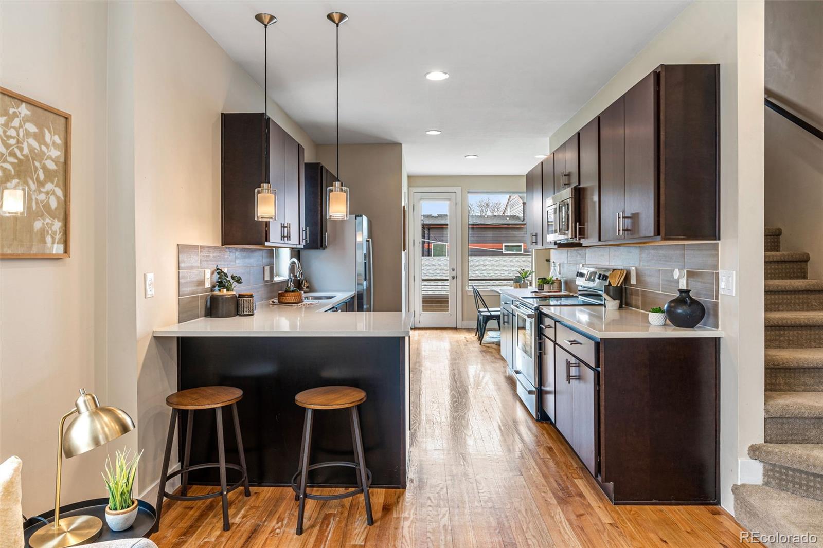 2146 Decatur Street Denver, CO 80211 - Photo 3 of 21 a kitchen with stainless steel appliances granite countertop wooden cabinets a dining table and chairs