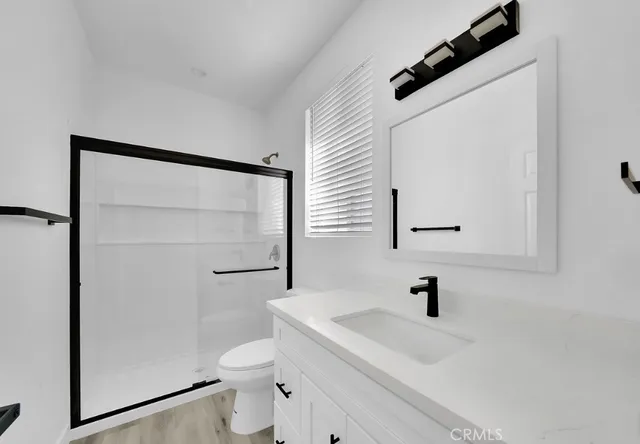 a view of empty room with wooden floor and ceiling fan