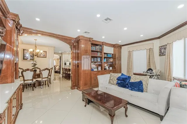 a living room with furniture kitchen view and a large window