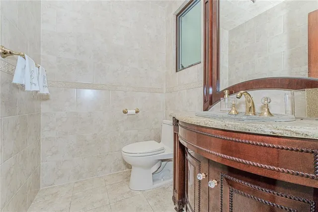 a bathroom with a granite countertop sink a toilet and a mirror