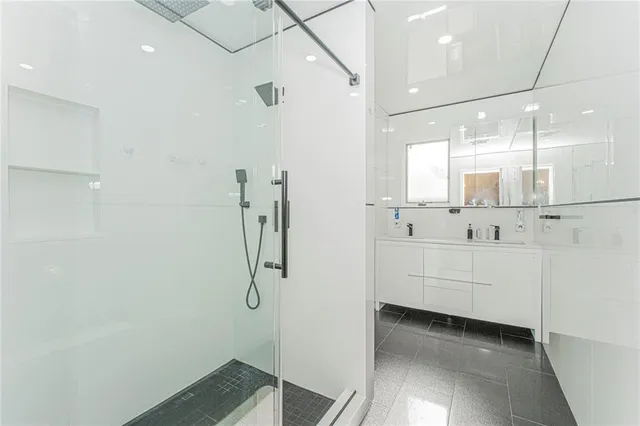 a bathroom with a shower and a sink a mirror