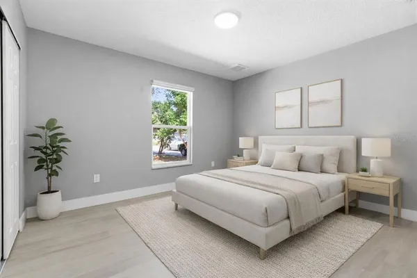 a bedroom with a large bed and a potted plant