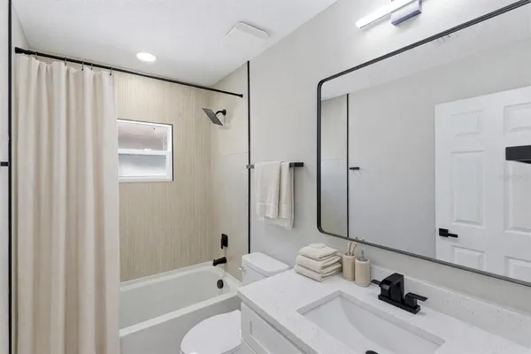 a bathroom with a bathtub shower sink and toilet
