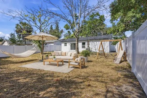 a view of a house with backyard and sitting area