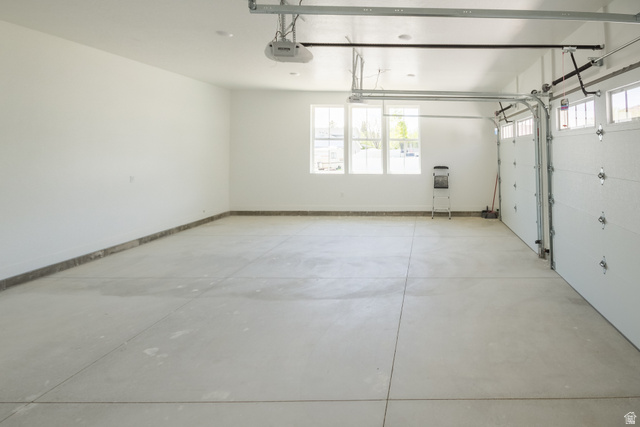 3322 250 S Street Vernal, UT 84078 - Photo 31 of 37 Spacious garage featuring a concrete floor, multiple windows providing natural light, and two overhead garage doors