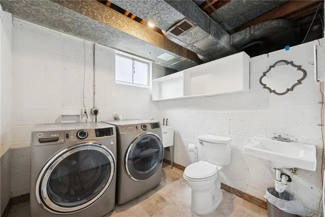 a bathroom with a washing machine and a sink