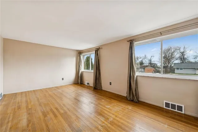 a view of a room with wooden floor and window