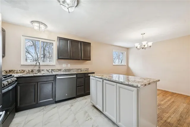 a kitchen with stainless steel appliances granite countertop a sink stove and cabinets