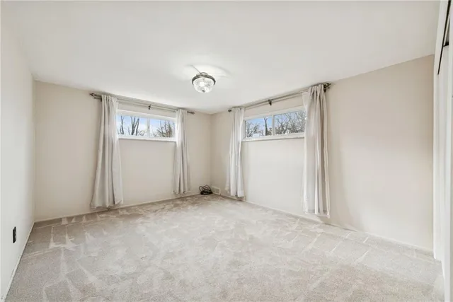 an empty room with windows and closet